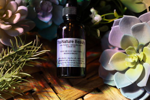 Bottle of Tru-Nature Beauty cuticle oil with succulent plants in the background