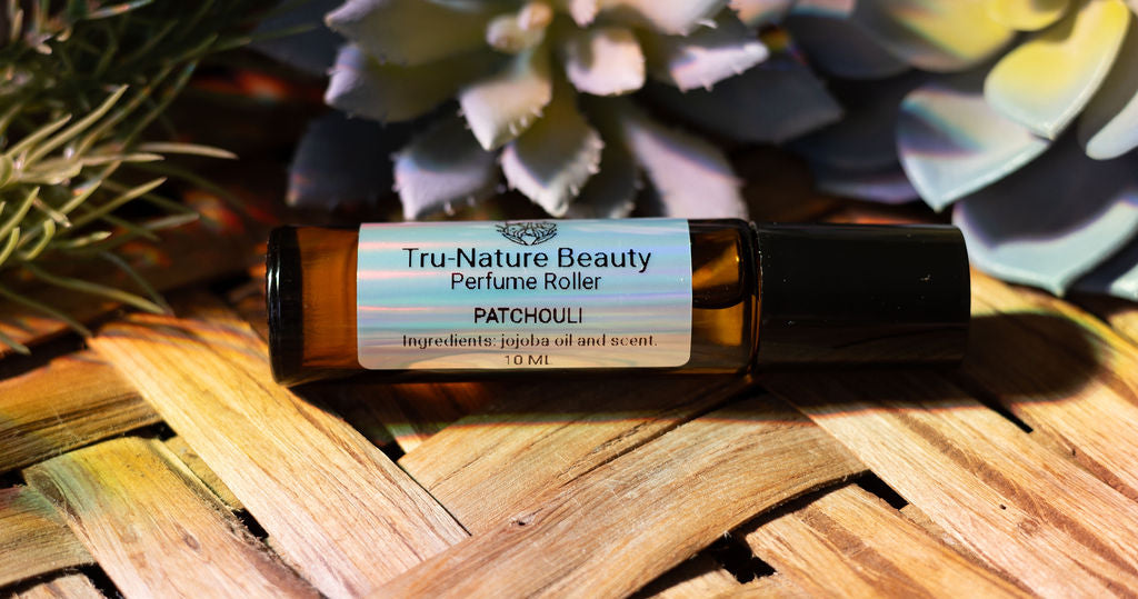 Tru-Nature Beauty Patchouli perfume roller bottle on a woven surface with plants in the background