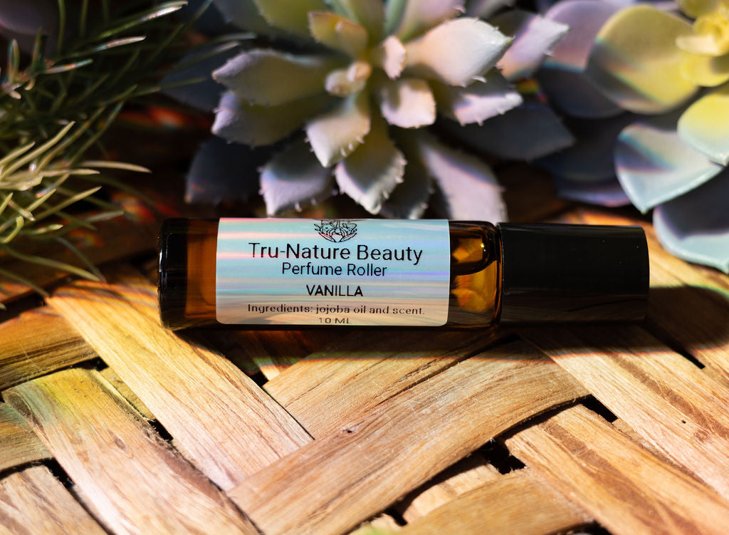 Tru-Nature Beauty vanilla perfume roller on a woven surface with plants in the background