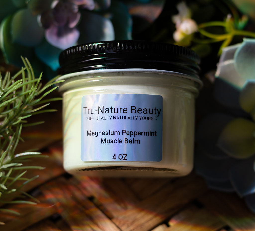 Jar of magnesium peppermint muscle balm with 'Tru-Nature Beauty' label on a wooden surface with plants.