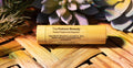 Tru-Nature Beauty natural peppermint chapstick on a wooden surface with plants in the background