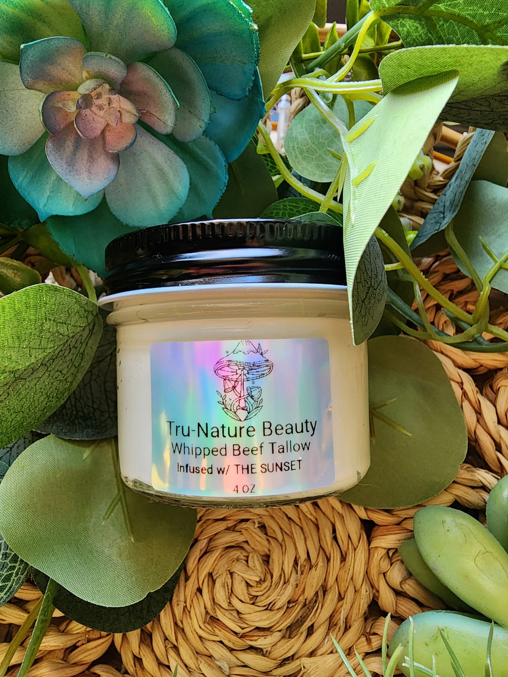 Jar of Tru-Nature Beauty whipped beef tallow product surrounded by greenery