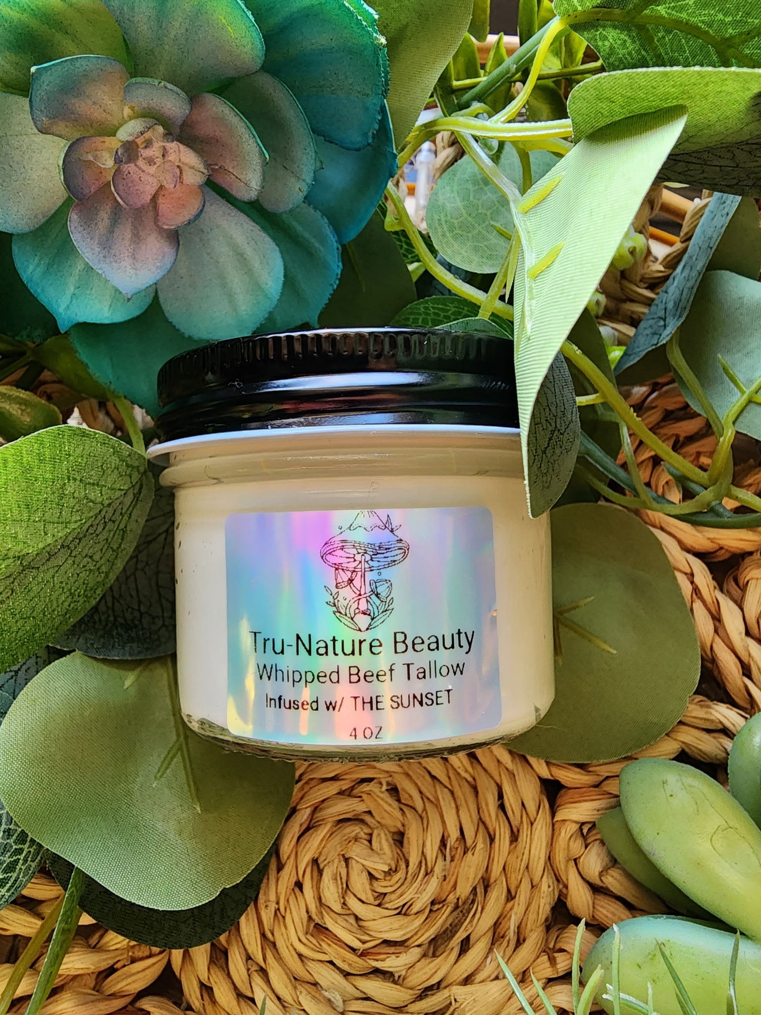 Jar of Tru-Nature Beauty whipped beef tallow product surrounded by greenery