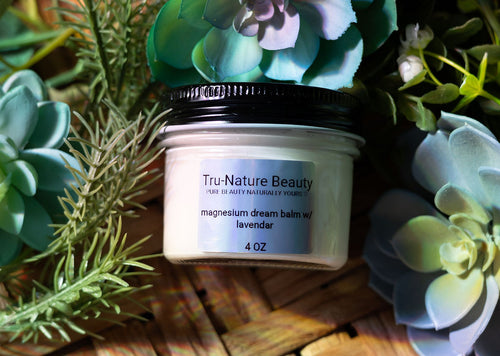 Tru-Nature Beauty magnesium balm jar surrounded by succulents on a wooden surface
