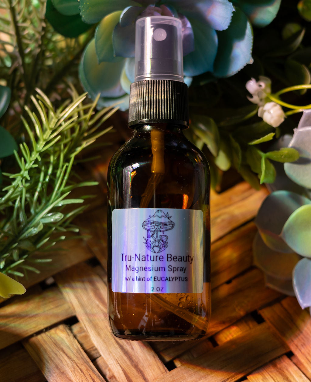 Brown glass bottle with a label on a wooden surface with greenery in the background