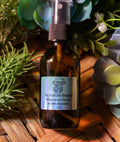 Brown glass bottle of Tru Nature Beauty Magnesium Spray with plants in the background