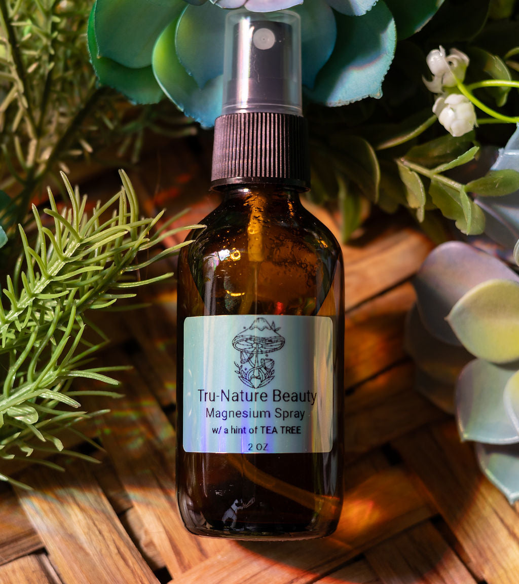 Brown glass bottle of Tru-Nature Beauty magnesium spray with a label, surrounded by greenery.