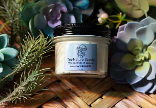 Jar of Tru Nature Beauty whipped beef tallow balm on a woven surface with plants in the background