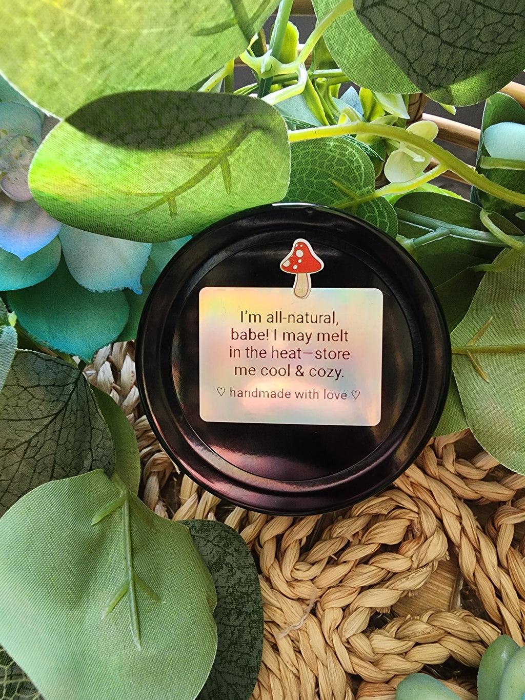 Jar lid from whipped beef tallow with a message surrounded by green leaves and woven material