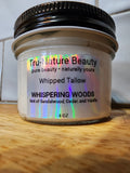 A 4 oz jar of Tru-Nature Beauty Whipped Tallow body butter in the scent Whispering Woods, resting on a wooden surface with a tiled background.